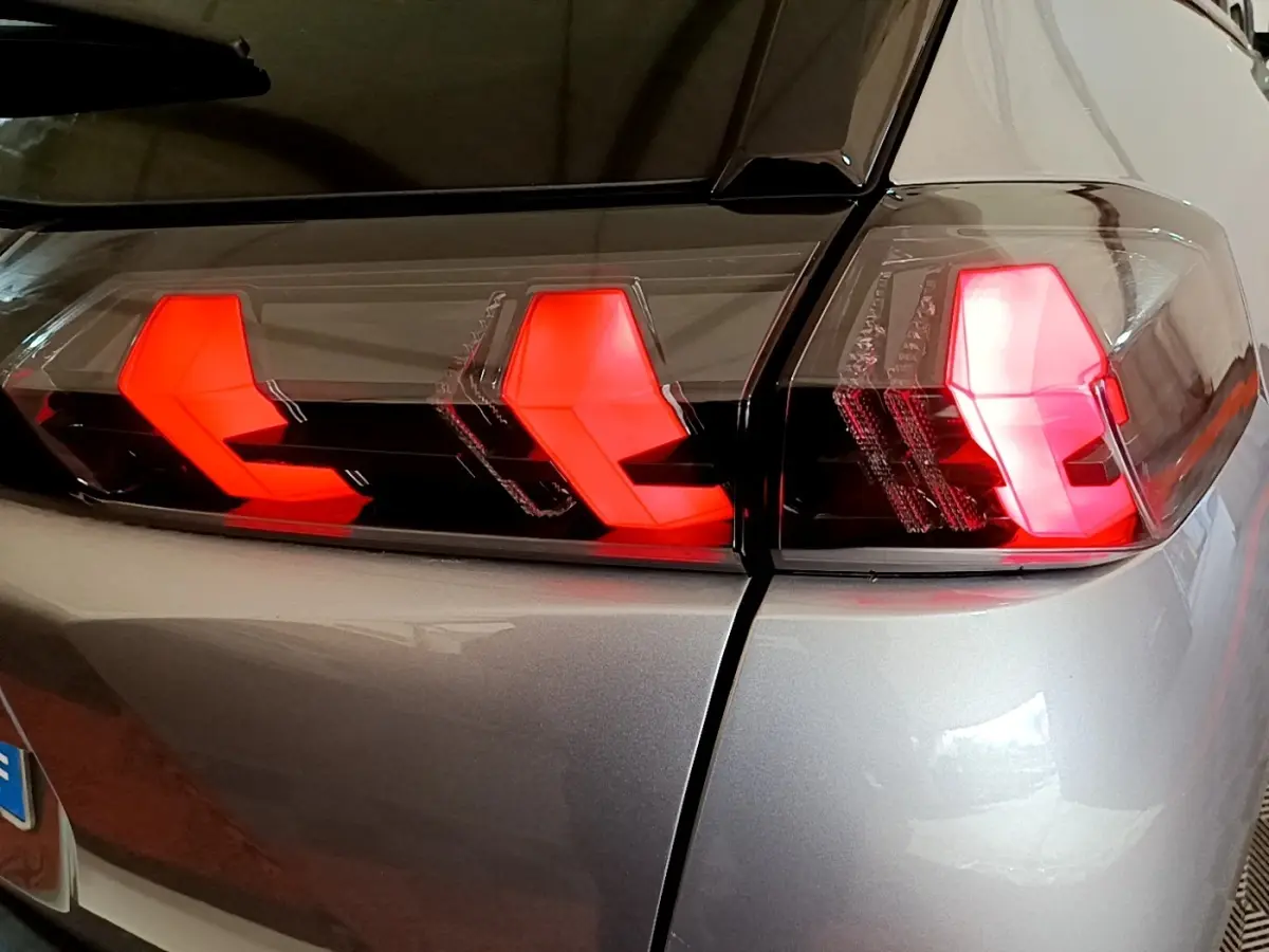 Gros plan sur le feu arrière droit rouge du Peugeot 2008 gris clair, soulignant la finition moderne du modèle 2021.