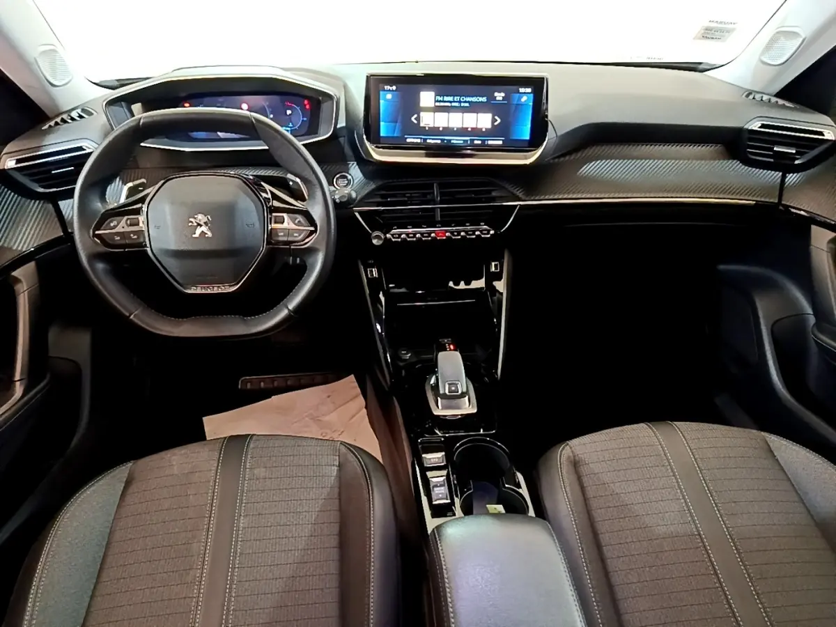 Vue intérieure avant du Peugeot 2008 2021, tableau de bord avec écran tactile 10 pouces et volant cuir multifonctions.