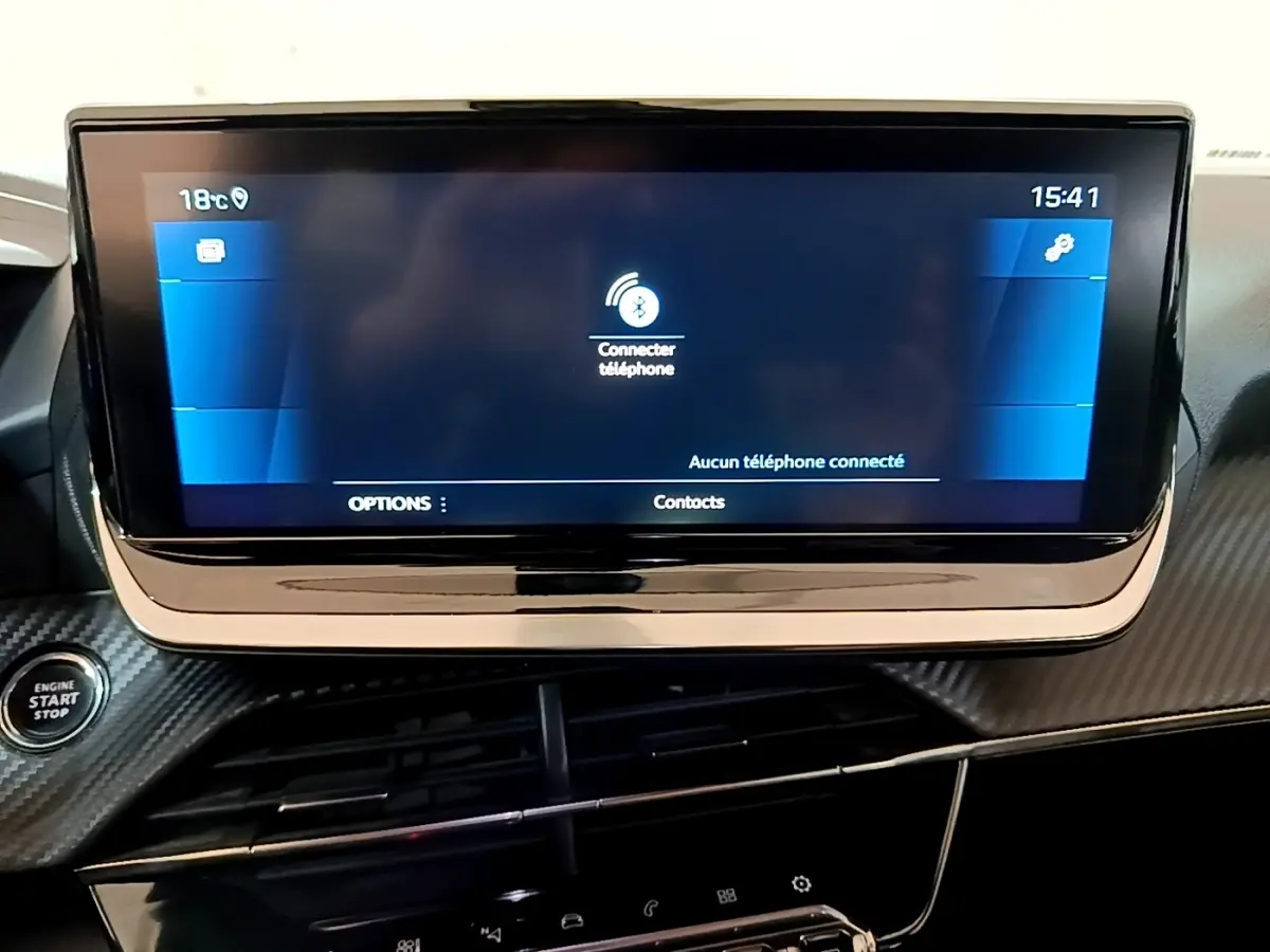 Écran tactile central allumé du tableau de bord du Peugeot 2008 gris, avec bouton démarrage visible à gauche.