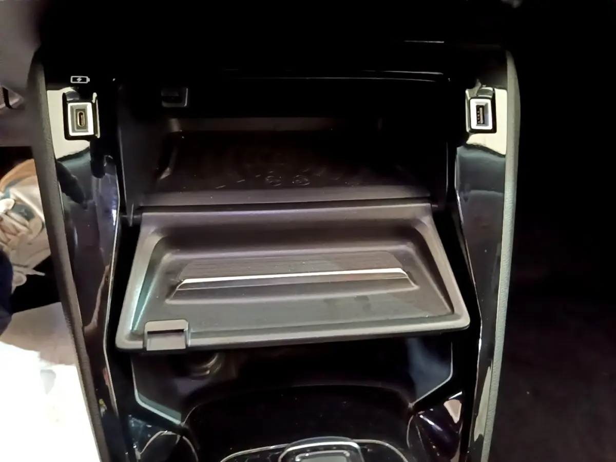 Gros plan sur la console centrale noire du Peugeot 2008 1.5 BlueHDi, avec compartiment ouvert et ports USB visibles.