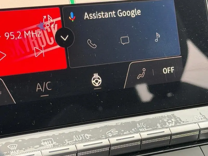 Écran tactile central du Renault Captur 2026 avec commandes climatisation et assistant Google affichés.