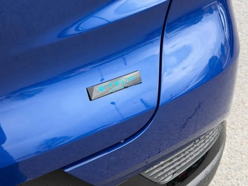 Gros plan sur l’inscription E-TECH Hybrid sur la partie avant droite du Renault Captur Bleu Iron 2026.