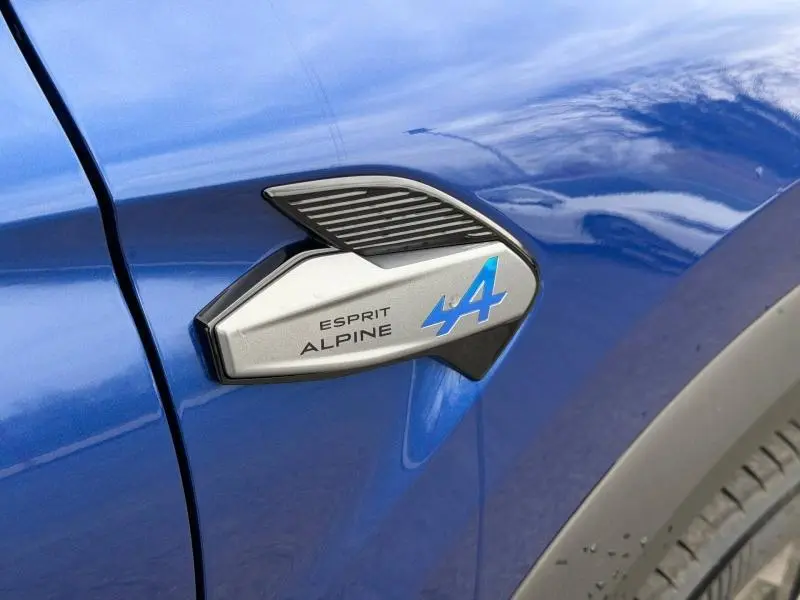 Détail du logo Esprit Alpine bleu sur l'aile avant gauche d'un Renault Captur Bleu Iron 2026.