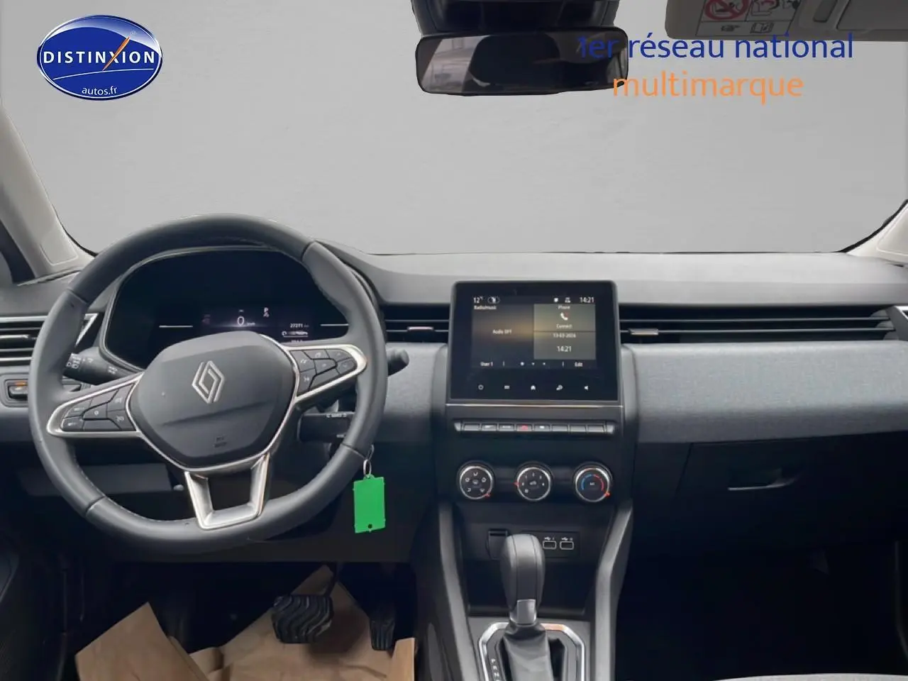 Vue frontale de l'intérieur gris de la Renault Clio V 2025 avec volant multifonction et écran tactile central.