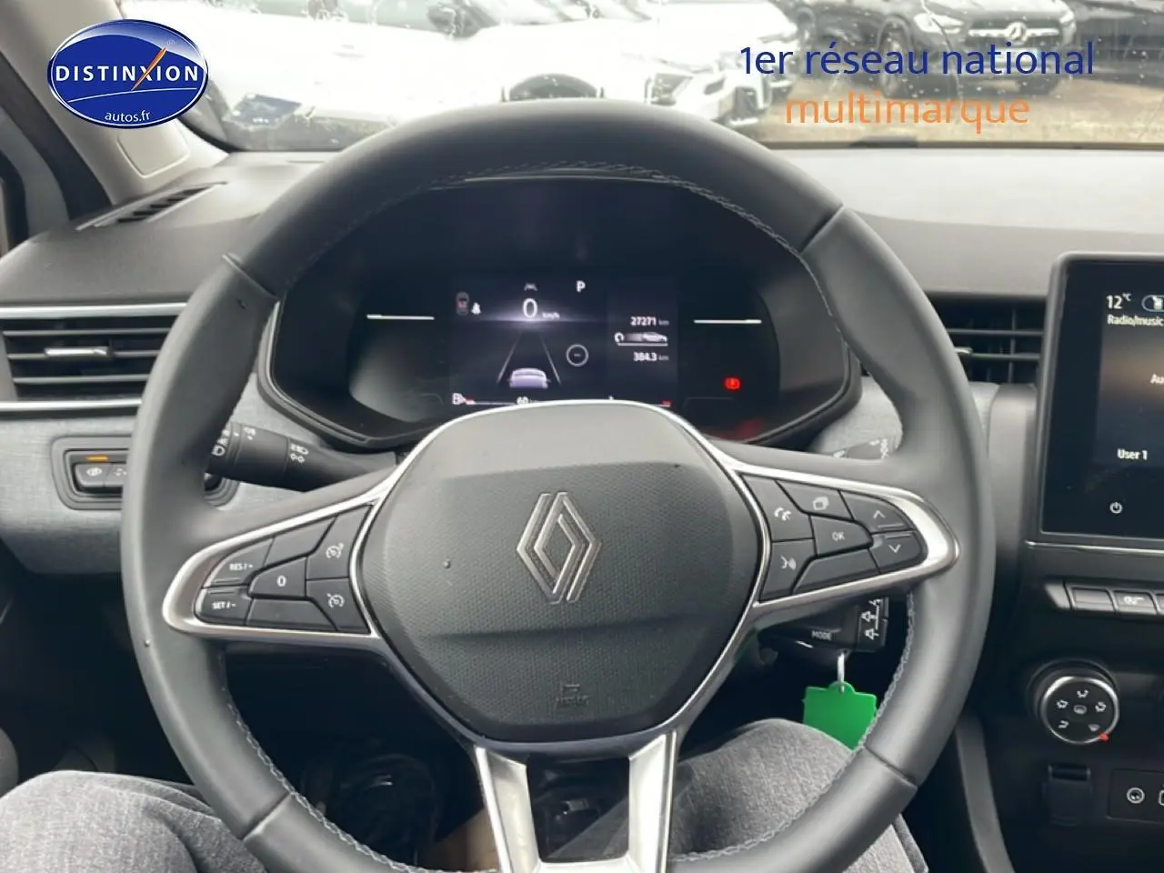 Vue intérieure centrée sur le volant multifonction noir de la Renault Clio V 2025 avec tableau de bord digital et écran tactile.