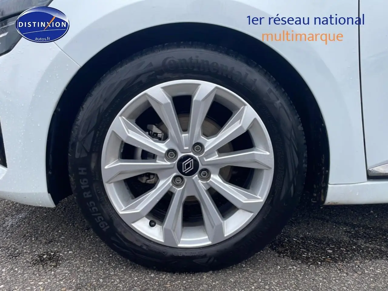 Gros plan sur la roue avant droite avec jante alliage argentée de la Renault Clio V blanche vue de profil.