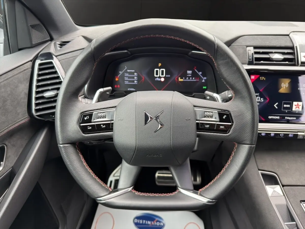 Vue frontale du volant cuir noir avec surpiqûres rouges du DS7 Crossback 2022, tableau de bord digital et écran tactile visibles.
