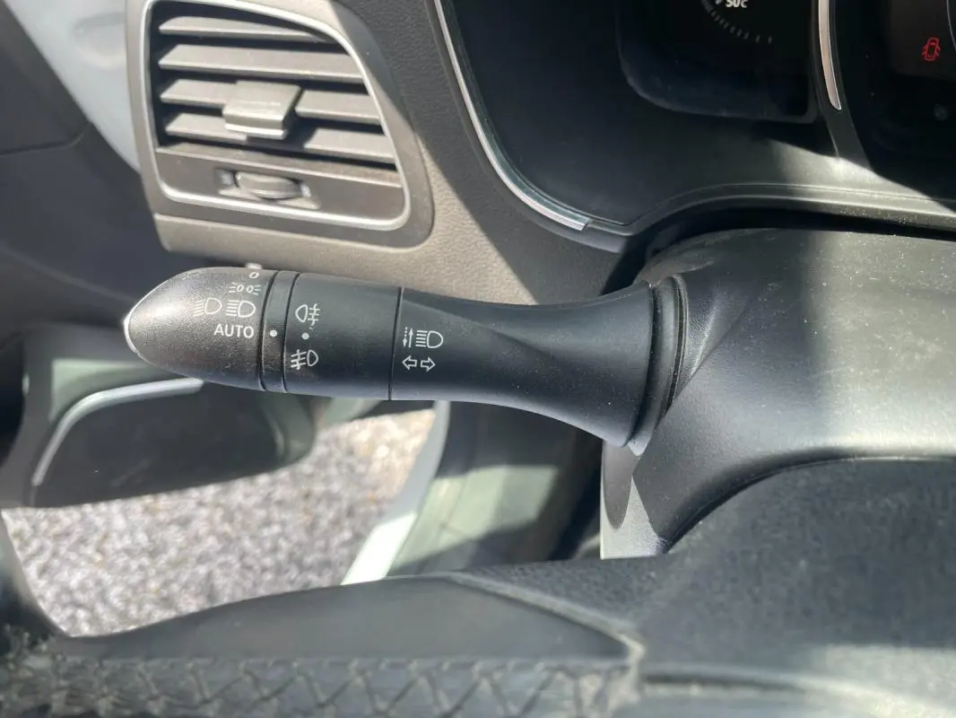 Gros plan sur la commande des phares et clignotants dans l’habitacle d’une Renault Mégane IV blanche de 2016.