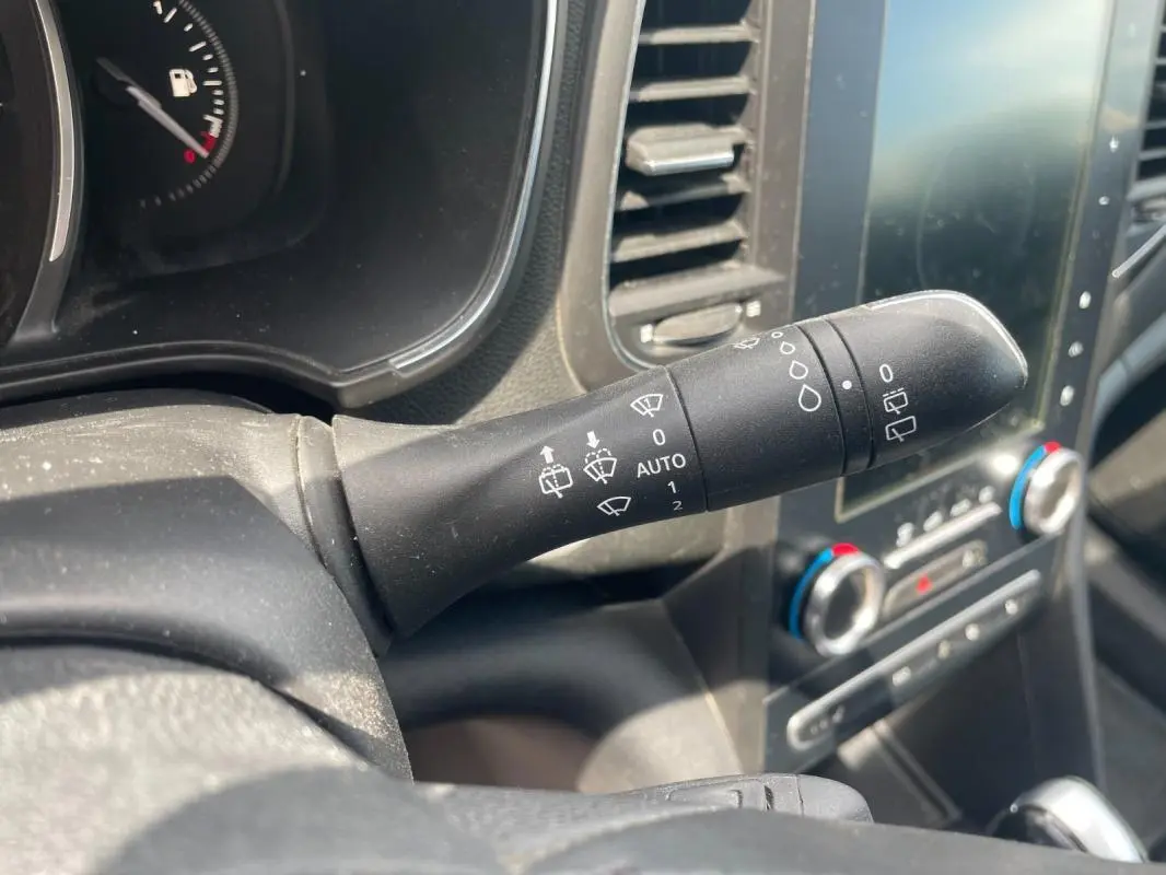 Gros plan sur la commande d’essuie-glace noire dans l’habitacle d’une Renault Mégane IV blanche de 2016.