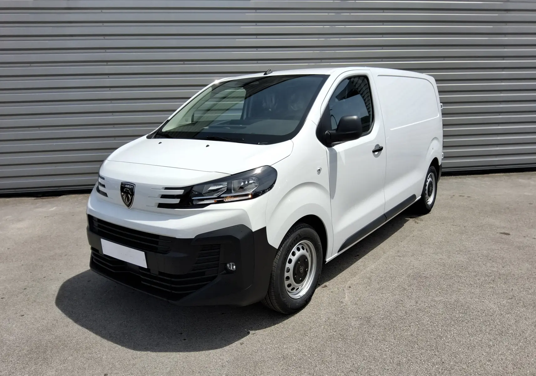 Vue 3/4 avant d'un Peugeot Expert Fourgon blanc 2025 avec pare-chocs noir et jantes acier simples.