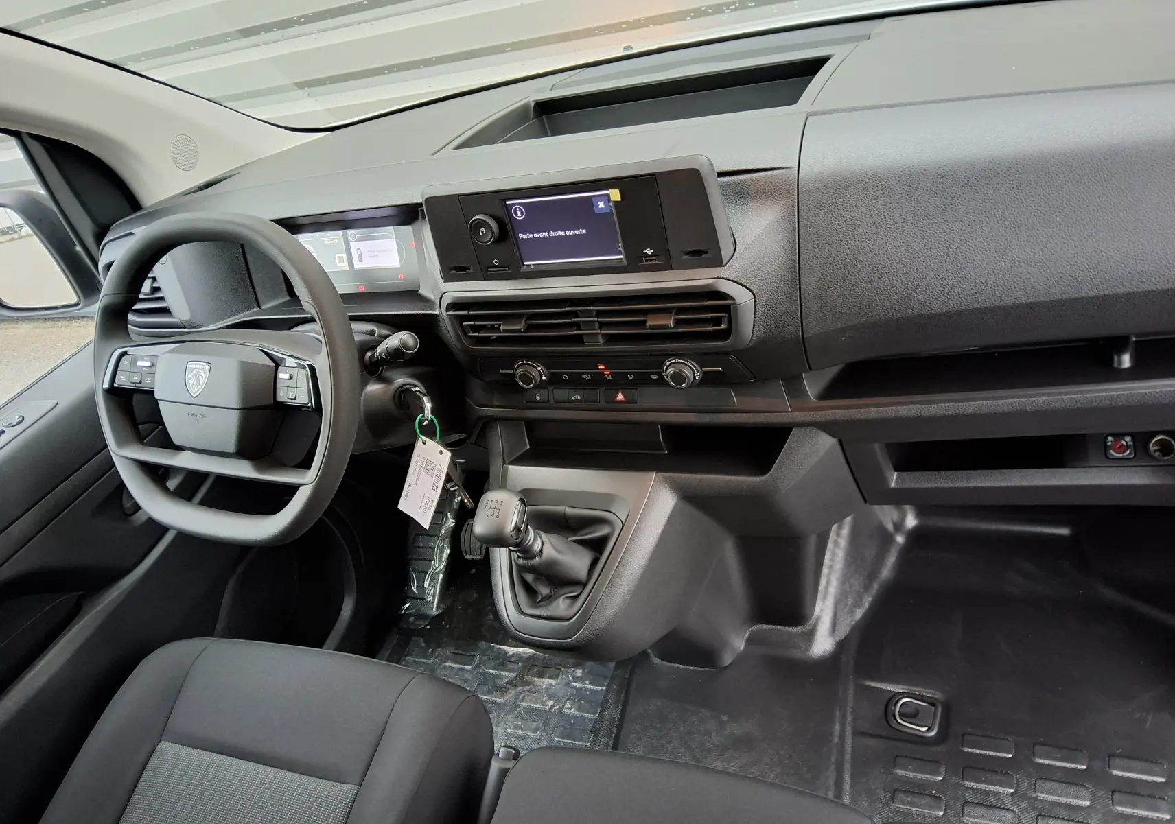 Vue intérieure côté conducteur du Peugeot Expert Fourgon blanc 2025, avec tableau de bord moderne et boîte manuelle.