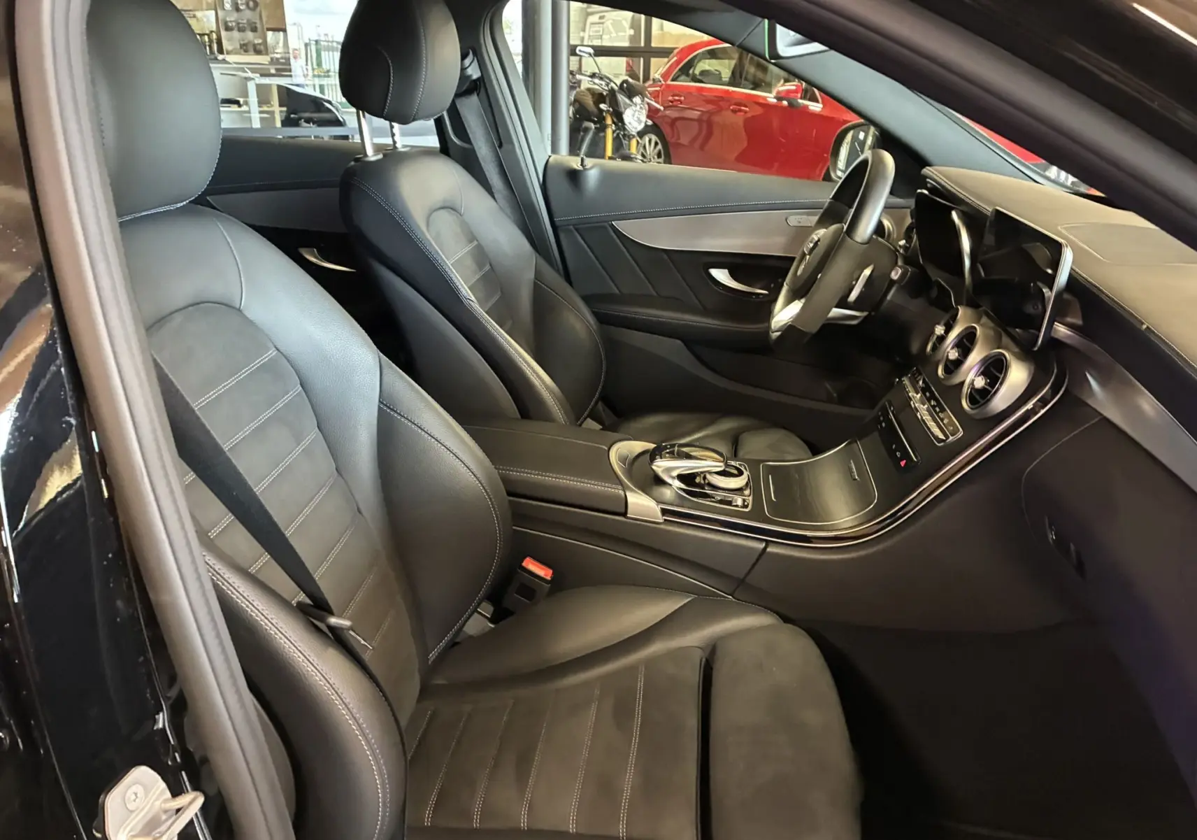Intérieur noir cuir et alcantara d'une Mercedes Classe C Break 220D AMG Line, vue côté conducteur avec tableau de bord moderne.