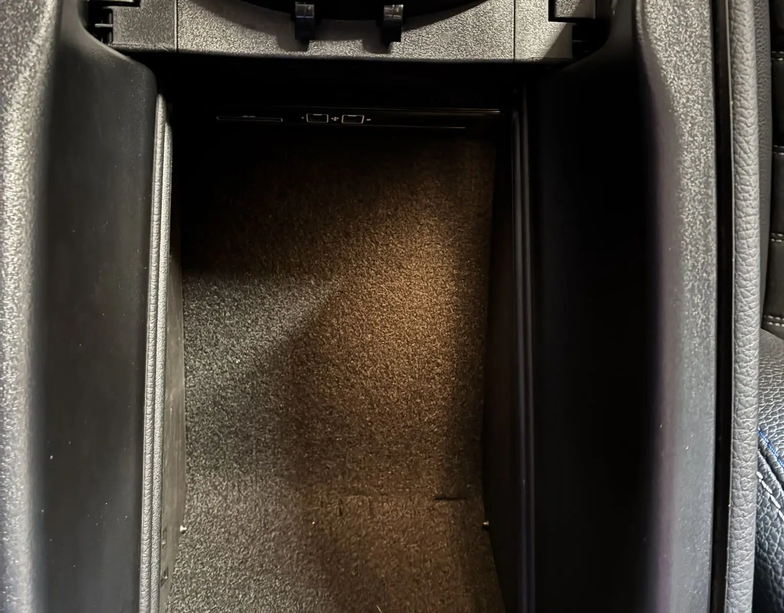 Vue plongeante sur le rangement central noir intérieur du Mercedes Classe C Break 220D AMG Line 2021.