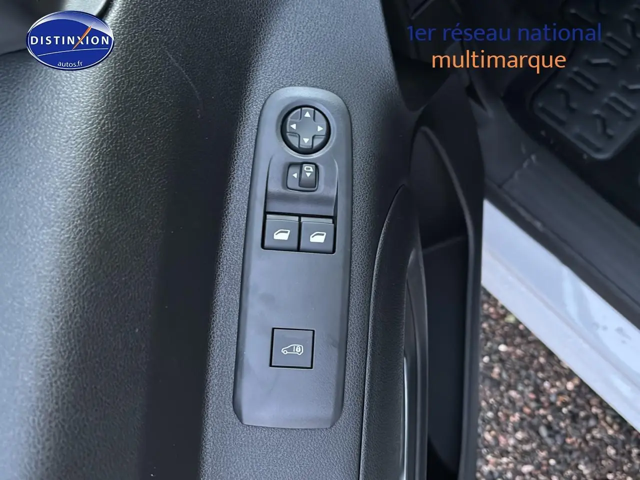 Vue rapprochée de la porte avant gauche blanche du Citroën Berlingo Fourgon avec commandes électriques des vitres et rétroviseurs.