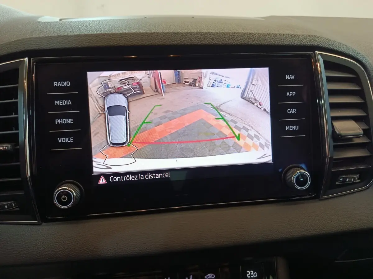 Écran tactile central affichant la caméra de recul avec guidage couleur dans un Skoda Karoq blanc 2024.