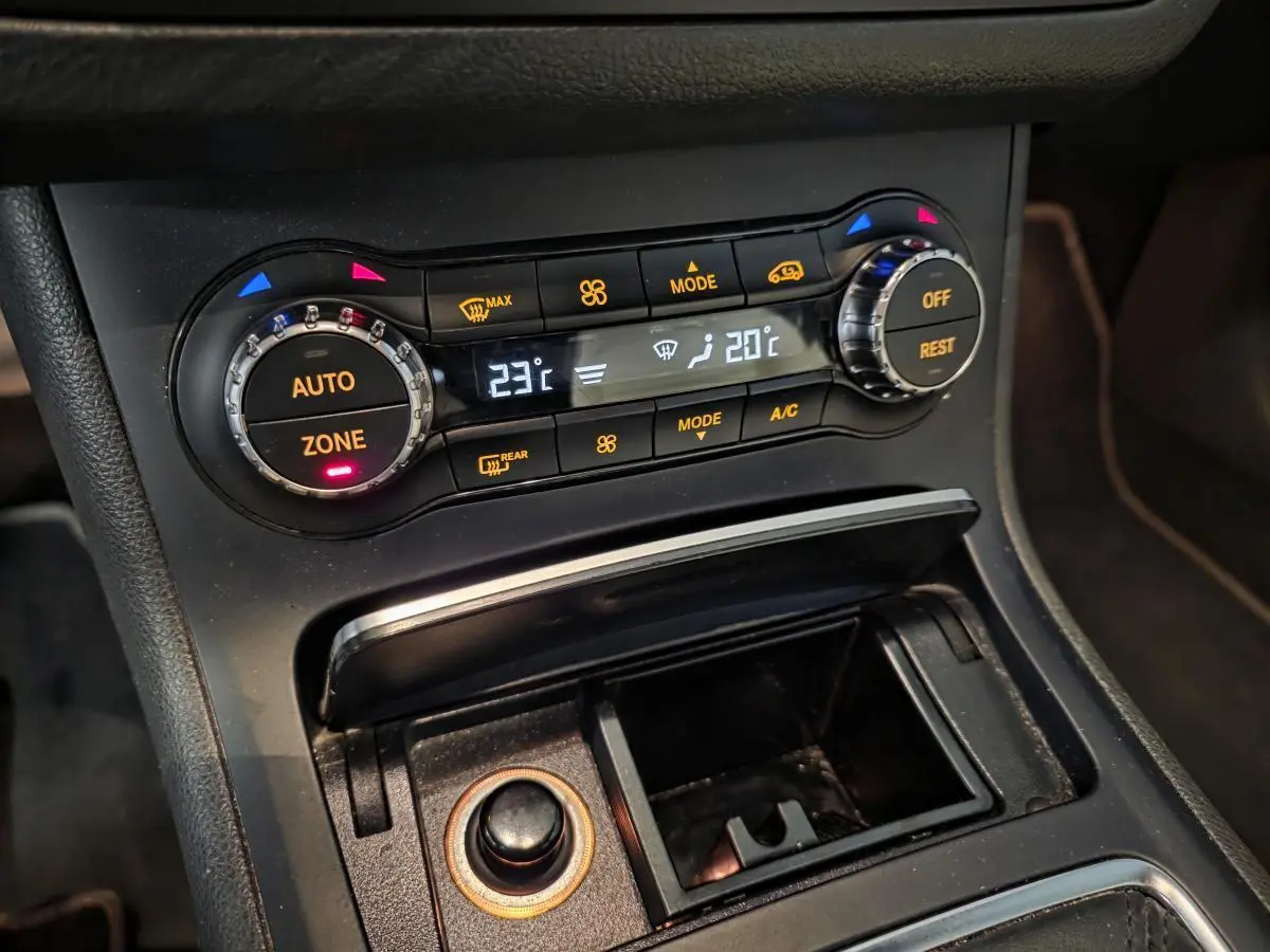 Gros plan sur la console centrale noire de la Mercedes Classe B 180 d 2018 avec commandes de climatisation et rangement ouvert.