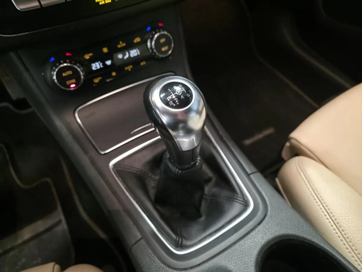 Gros plan sur le levier de vitesses manuel noir et argenté de la Mercedes Classe B 180 d Intuition, avec console centrale et siège beige visible.