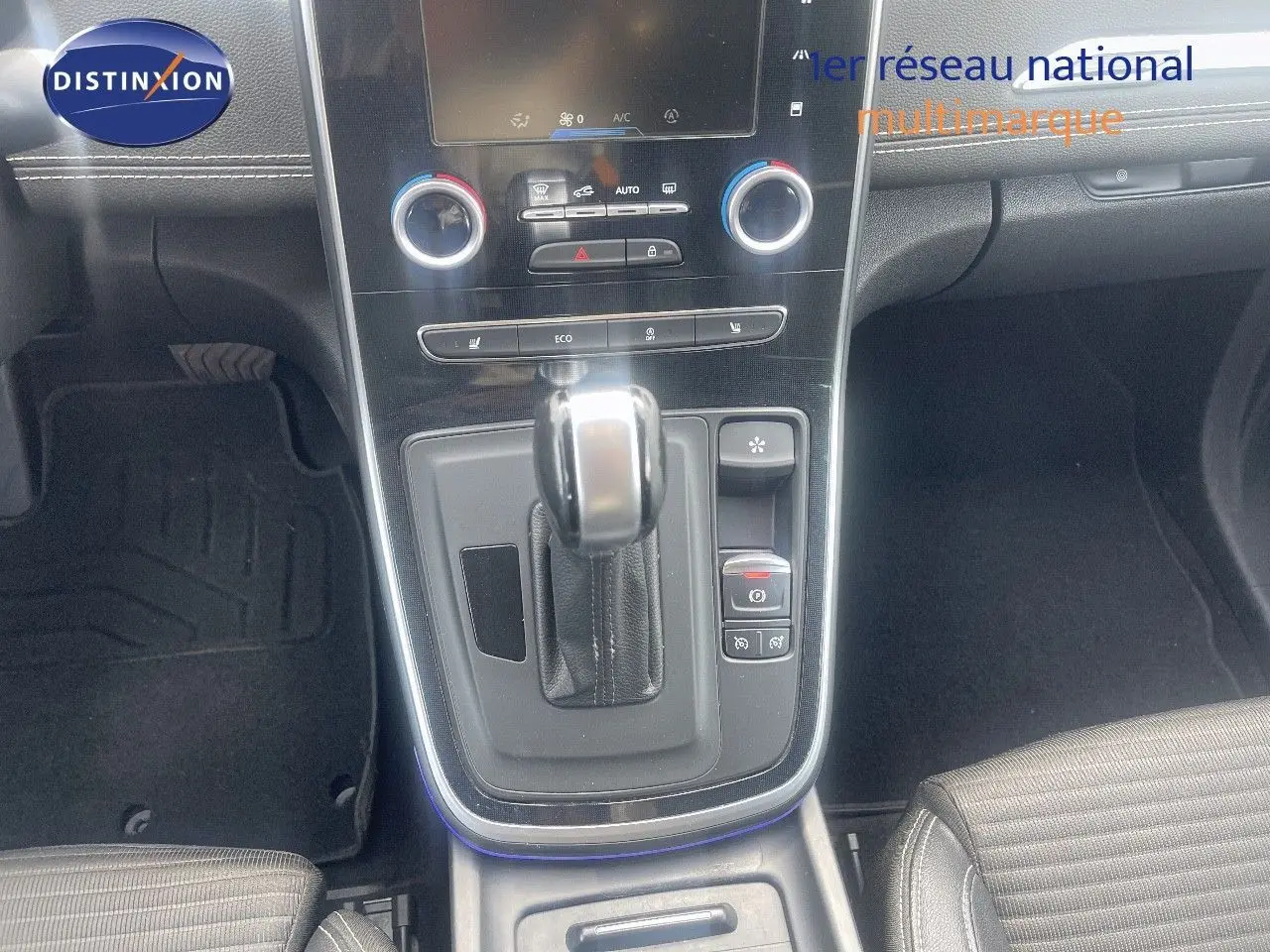 Gros plan sur la console centrale du Renault Scénic IV noir, mettant en valeur la boîte automatique et les commandes de climatisation.