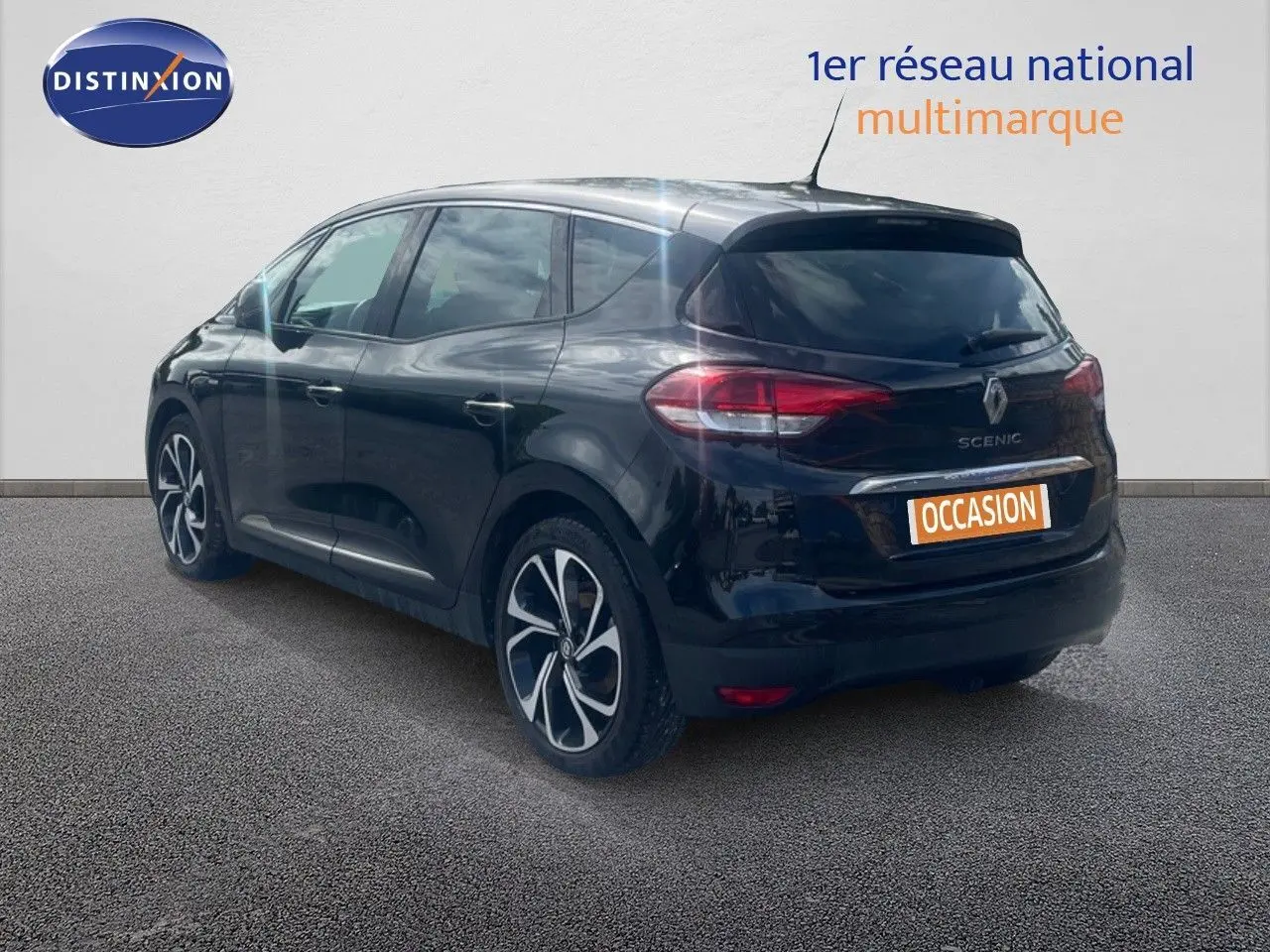 Renault Scénic IV noir en 3/4 arrière côté gauche, avec jantes alliage et feux arrière LED visibles.