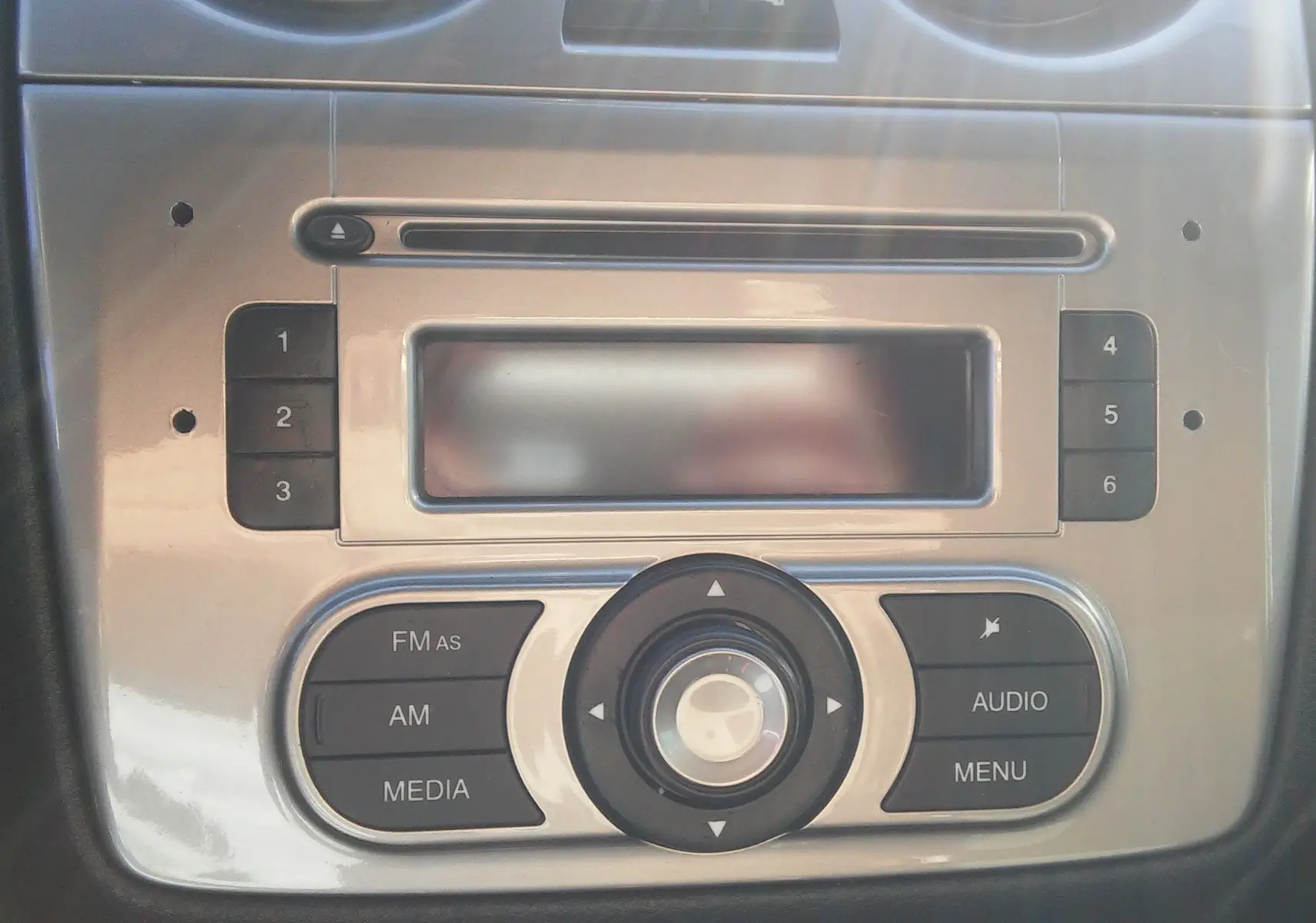 Gros plan sur la console centrale argentée de l'Alfa Romeo MiTo 2010, mettant en valeur les commandes audio et radio.