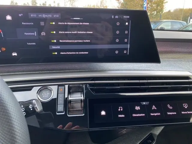 Tableau de bord du Peugeot 5008 2025 noir Perla, avec écran tactile affichant alertes de sécurité et commandes climatisation