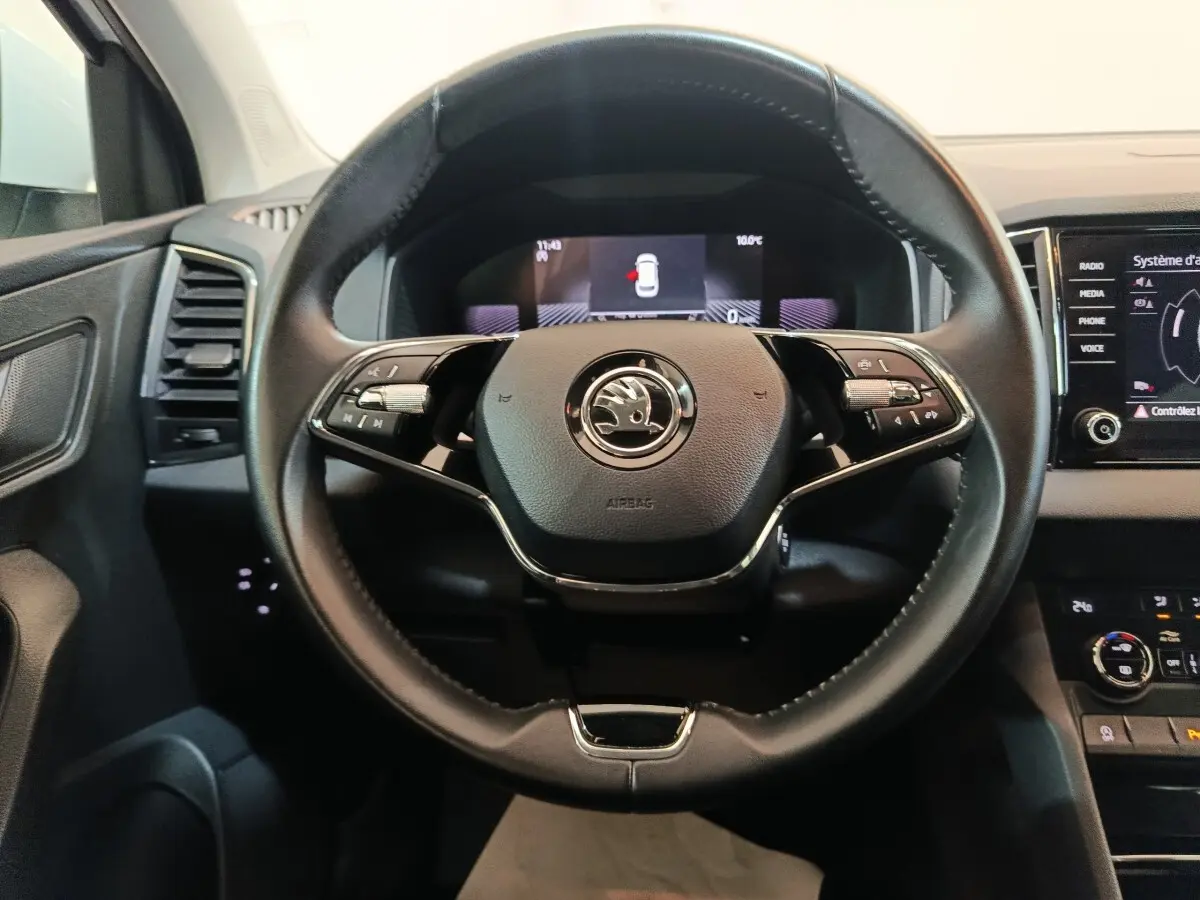 Vue frontale du volant cuir noir du Skoda Karoq 2024 avec tableau de bord digital et écran tactile central.