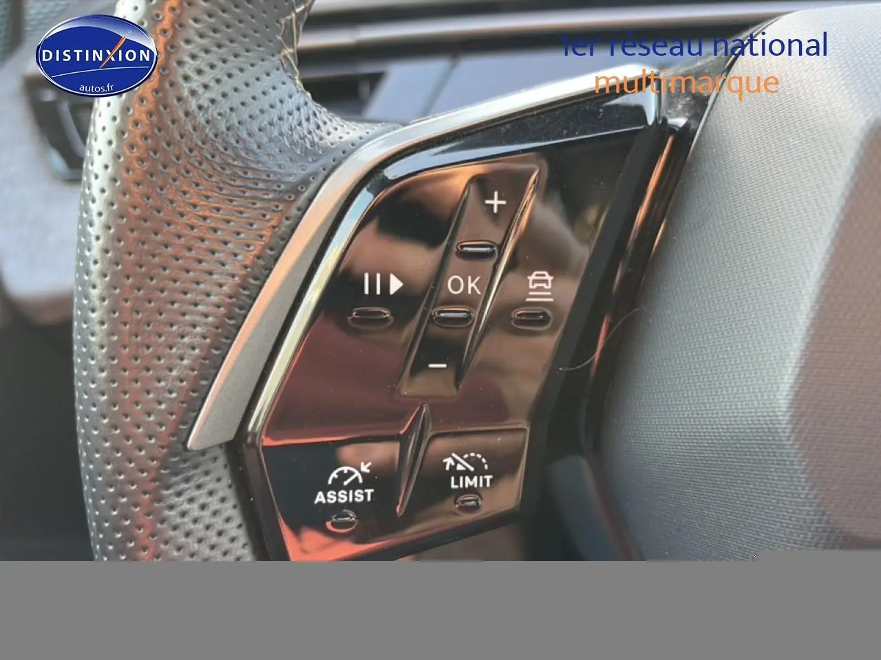 Gros plan sur les commandes noires du volant en cuir perforé du Peugeot 3008 gris 2025, côté gauche.