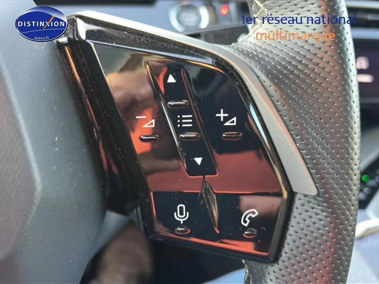 Gros plan sur les commandes vocales et téléphone du volant cuir perforé du Peugeot 3008 gris 2025.