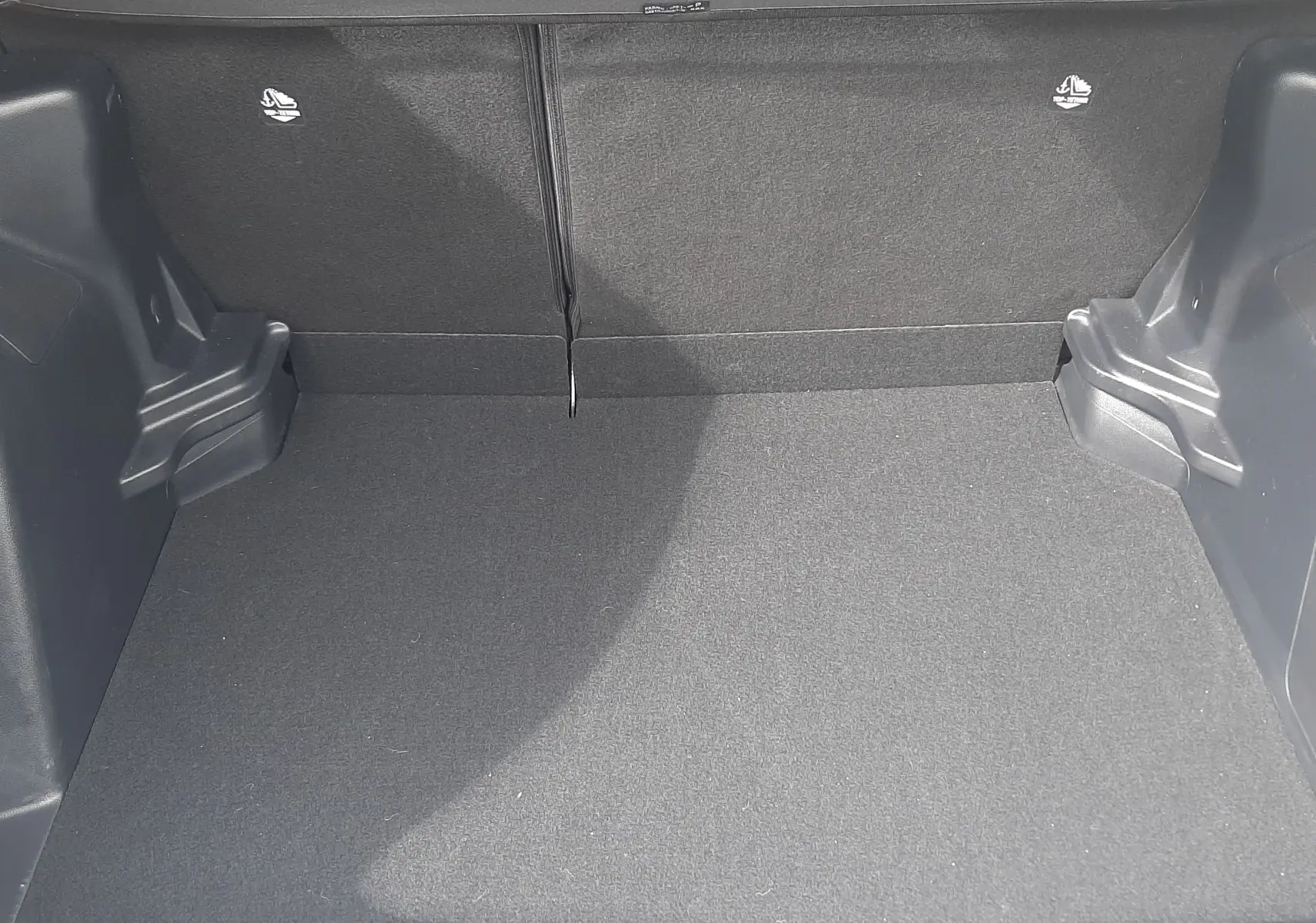 Coffre vide vu de face du Toyota Yaris Cross 2024 gris atlas métal, montrant l'espace de chargement et les finitions intérieures.