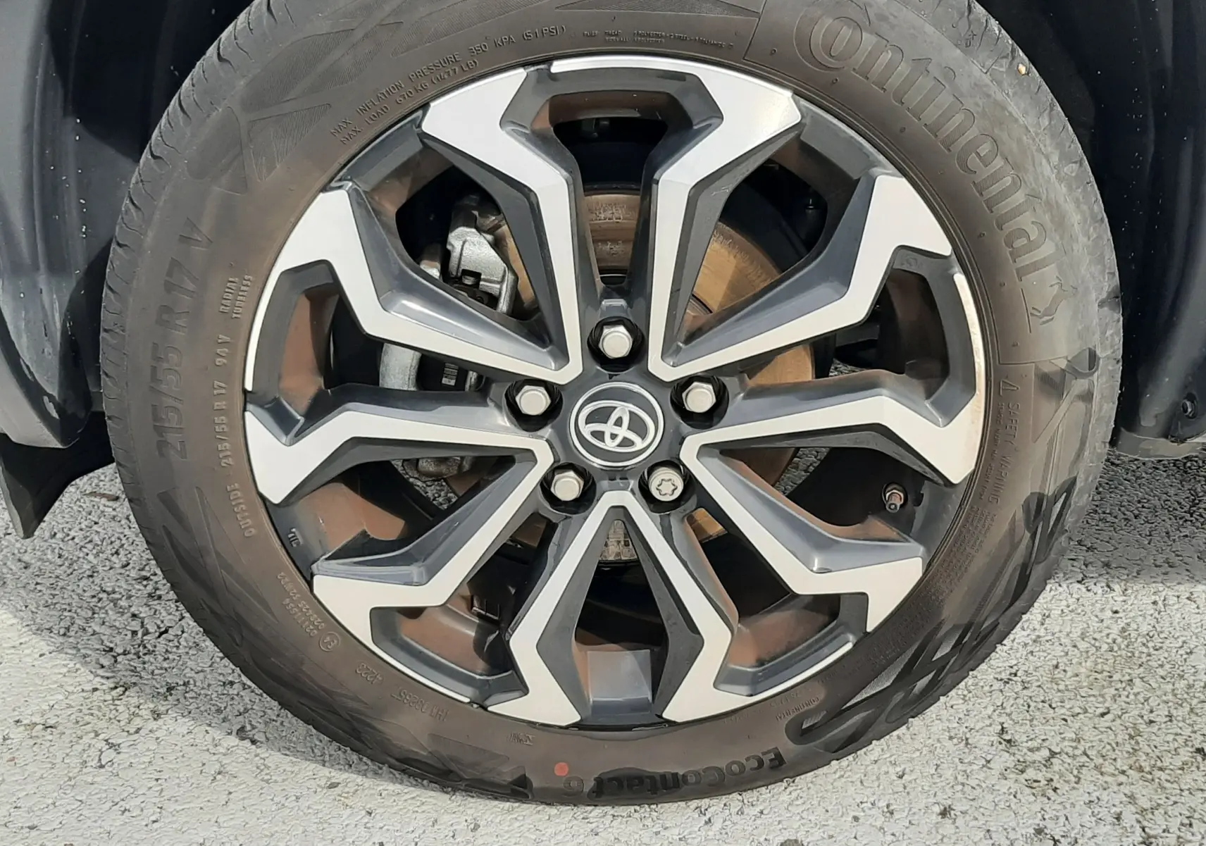 Gros plan sur la jante alliage bi-ton de 17 pouces avec logo Toyota, montée sur un pneu Continental.