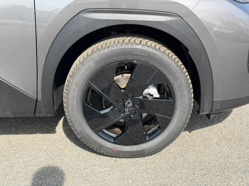 Gros plan sur la roue avant droite avec jante noire brillante du Citroën C5 Aircross gris Platinium.