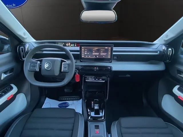 Vue intérieure frontale du tableau de bord de la Citroën C3 Hybrid 145 gris foncé avec écran tactile central et volant multifonction.