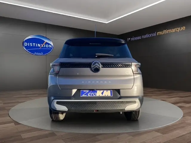 Vue arrière d'une Citroën C3 Aircross gris foncé, avec logo central et feux LED horizontaux, en showroom.
