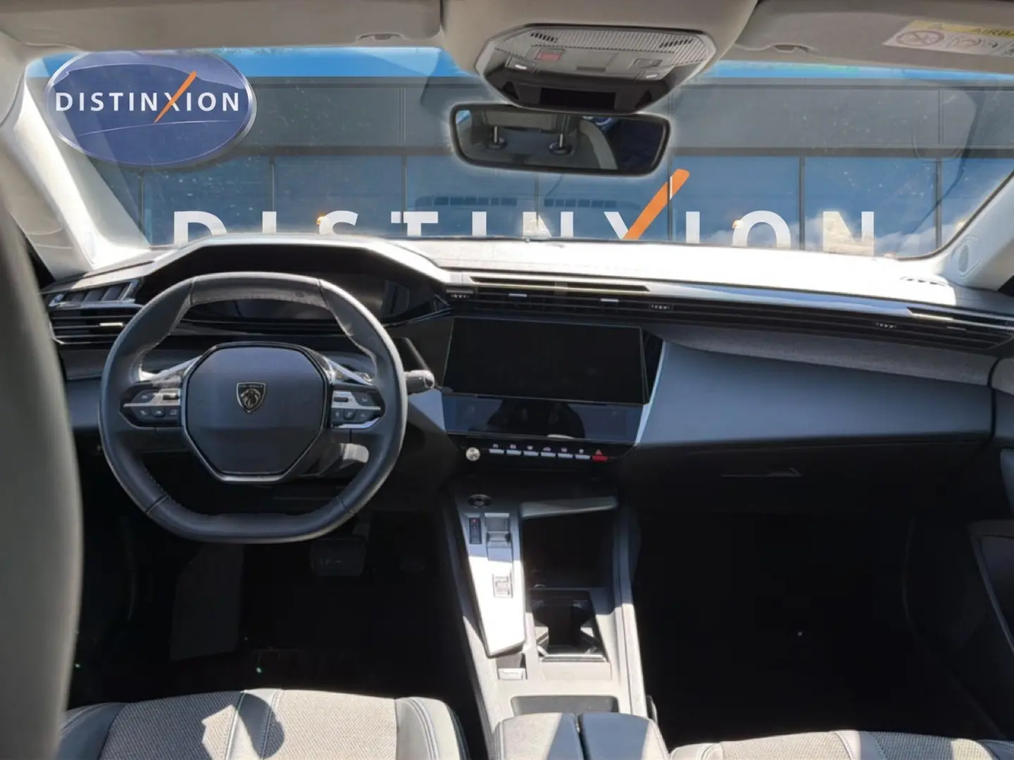 Vue intérieure avant du Peugeot 408 Hybrid 145 allure avec tableau de bord moderne et volant compact noir.