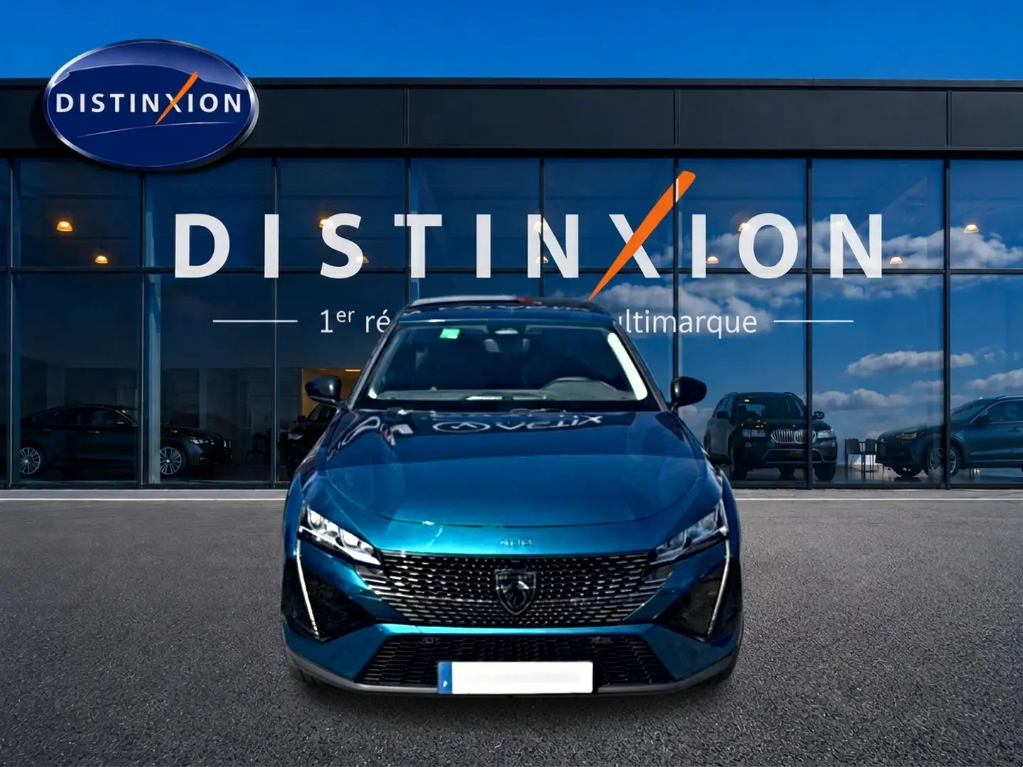 Vue frontale d'une Peugeot 408 Hybrid 145 allure e-dcs6 bleu, avec calandre distinctive et phares LED allumés.