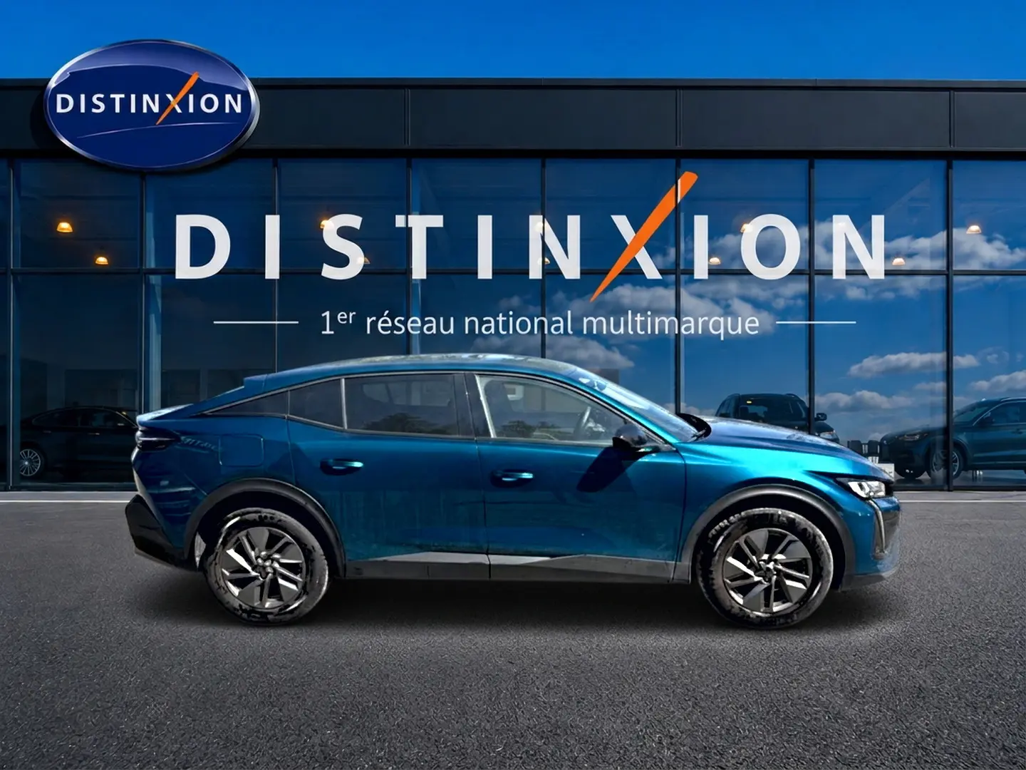 Vue latérale droite d'une Peugeot 408 Hybrid 145 allure e-dcs6 bleu avec jantes alu, devant une vitrine Distinxion.