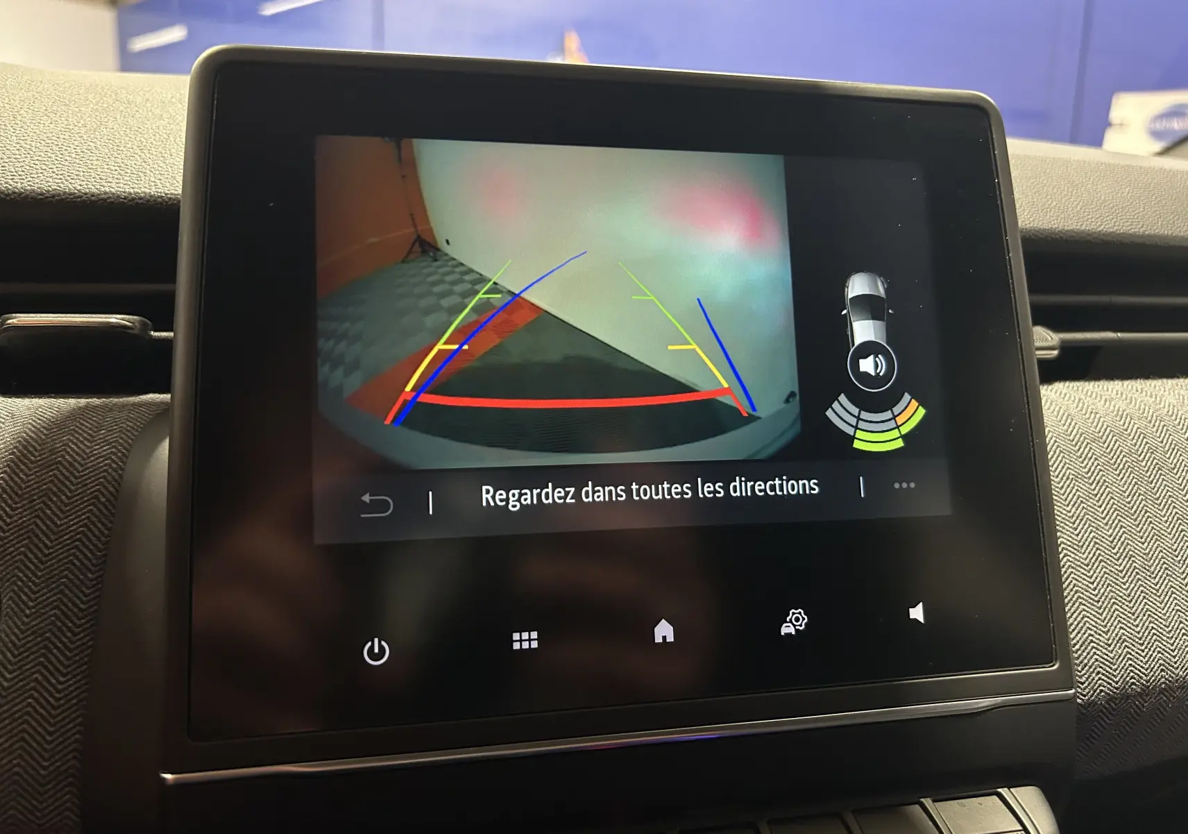 Écran central de la Renault Clio V gris Rafale montrant la caméra de recul avec guidage coloré et alertes sonores.