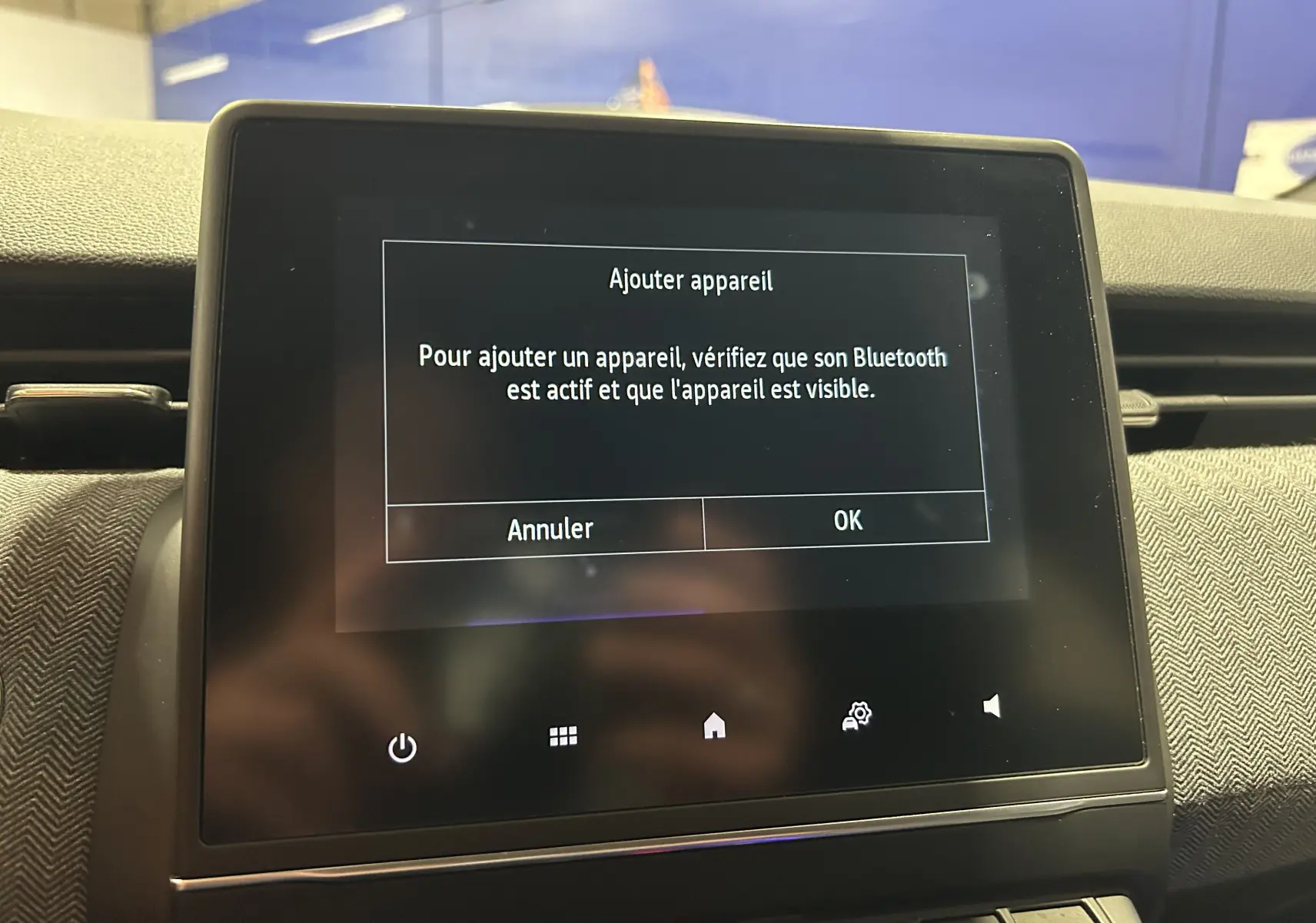 Écran tactile central de la Renault Clio V affichant un message d'ajout d'appareil Bluetooth, intérieur gris noir.