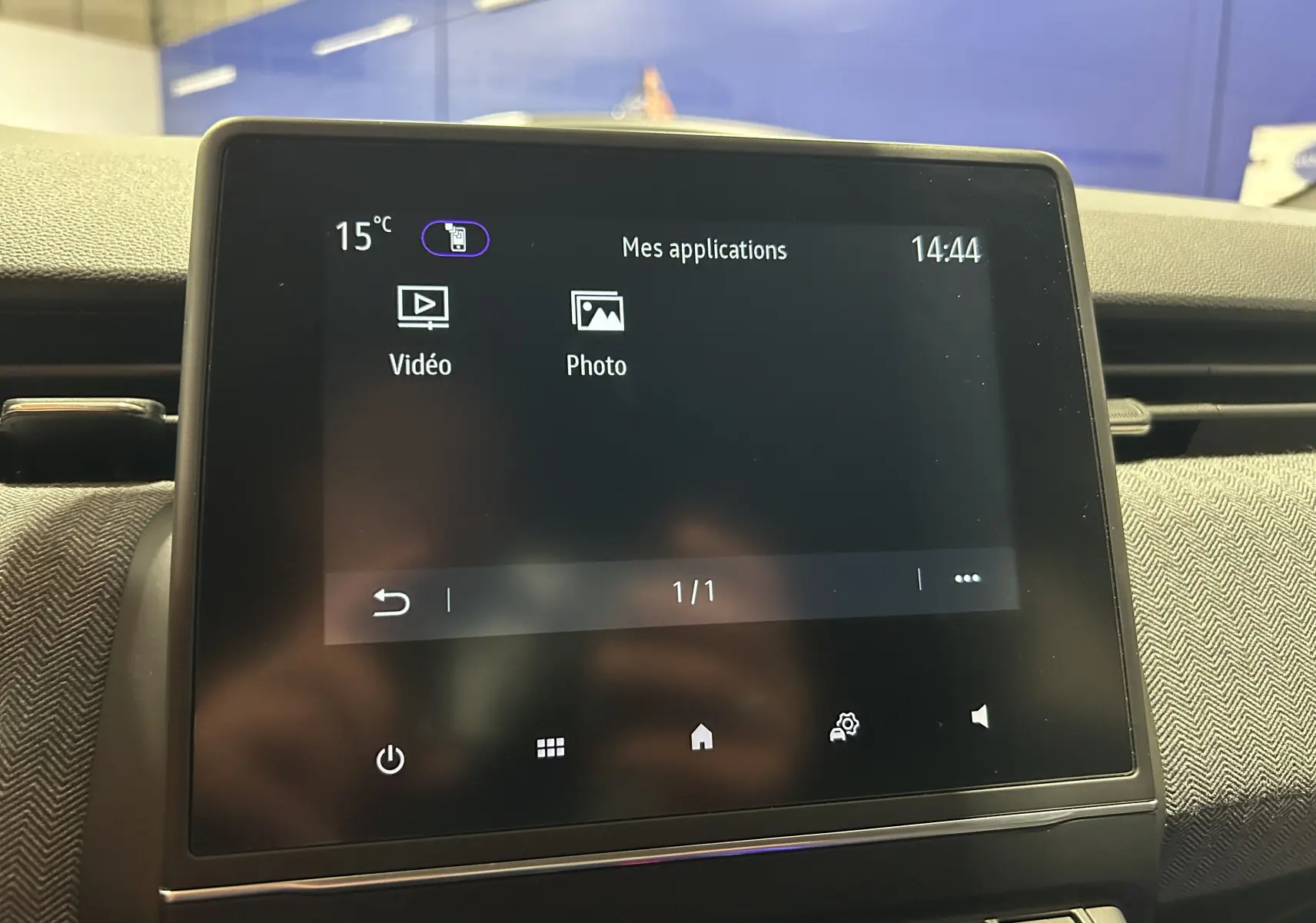 Écran tactile central de la Renault Clio V gris Rafale affichant les applications vidéo et photo en intérieur.