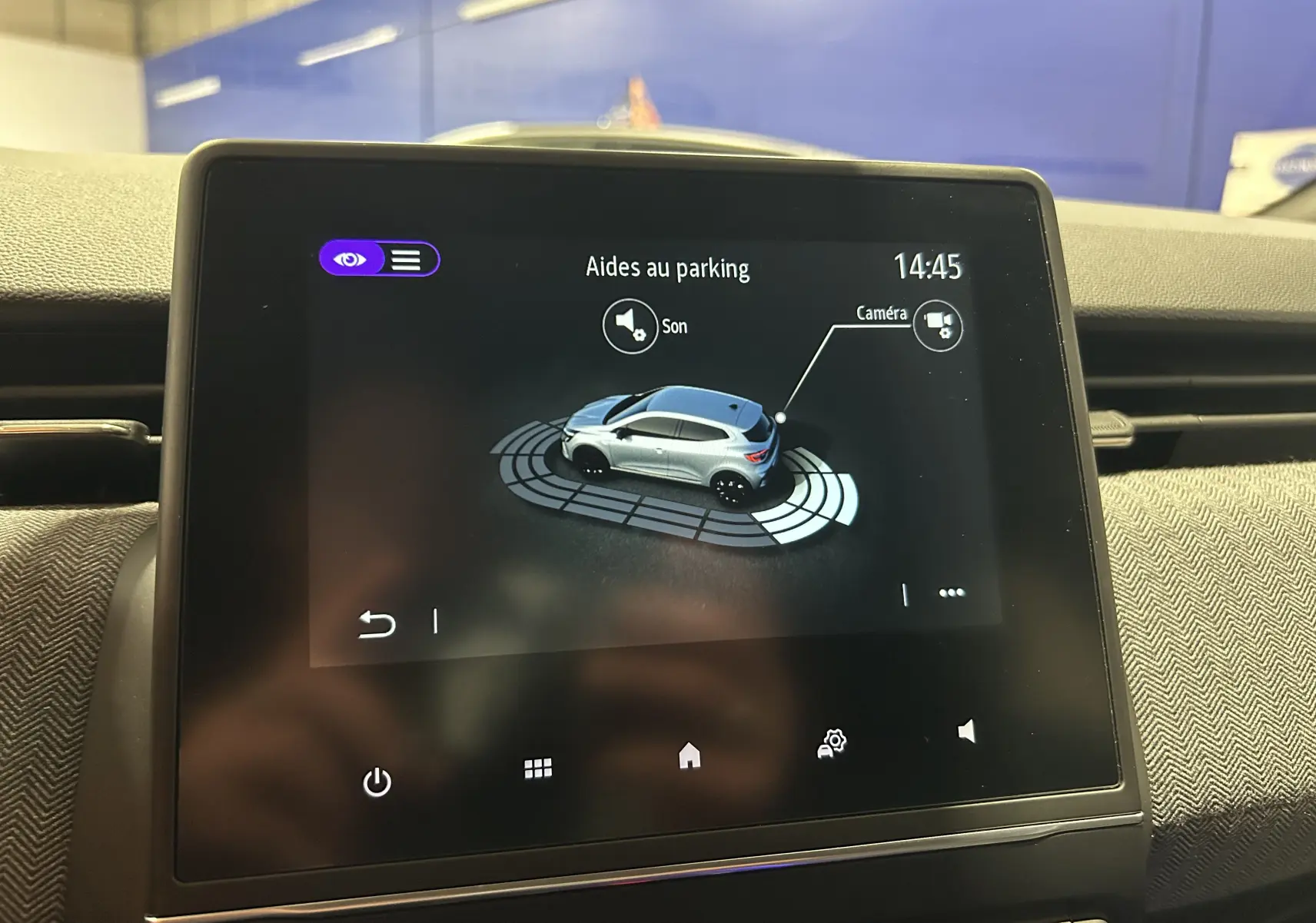 Écran tactile intérieur montrant l'aide au parking avec vue 3D d'une Renault Clio V gris Rafale.