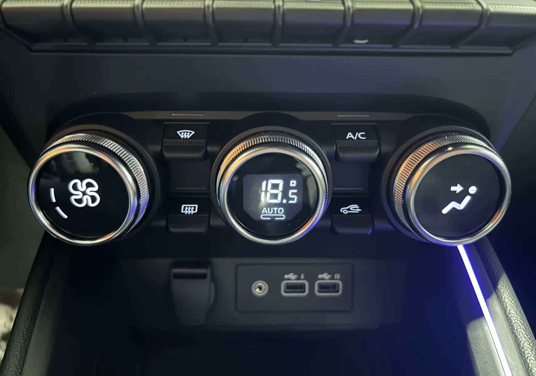 Gros plan sur les commandes de climatisation digitale à 18,5°C et ports USB de la Renault Clio V gris Rafale.