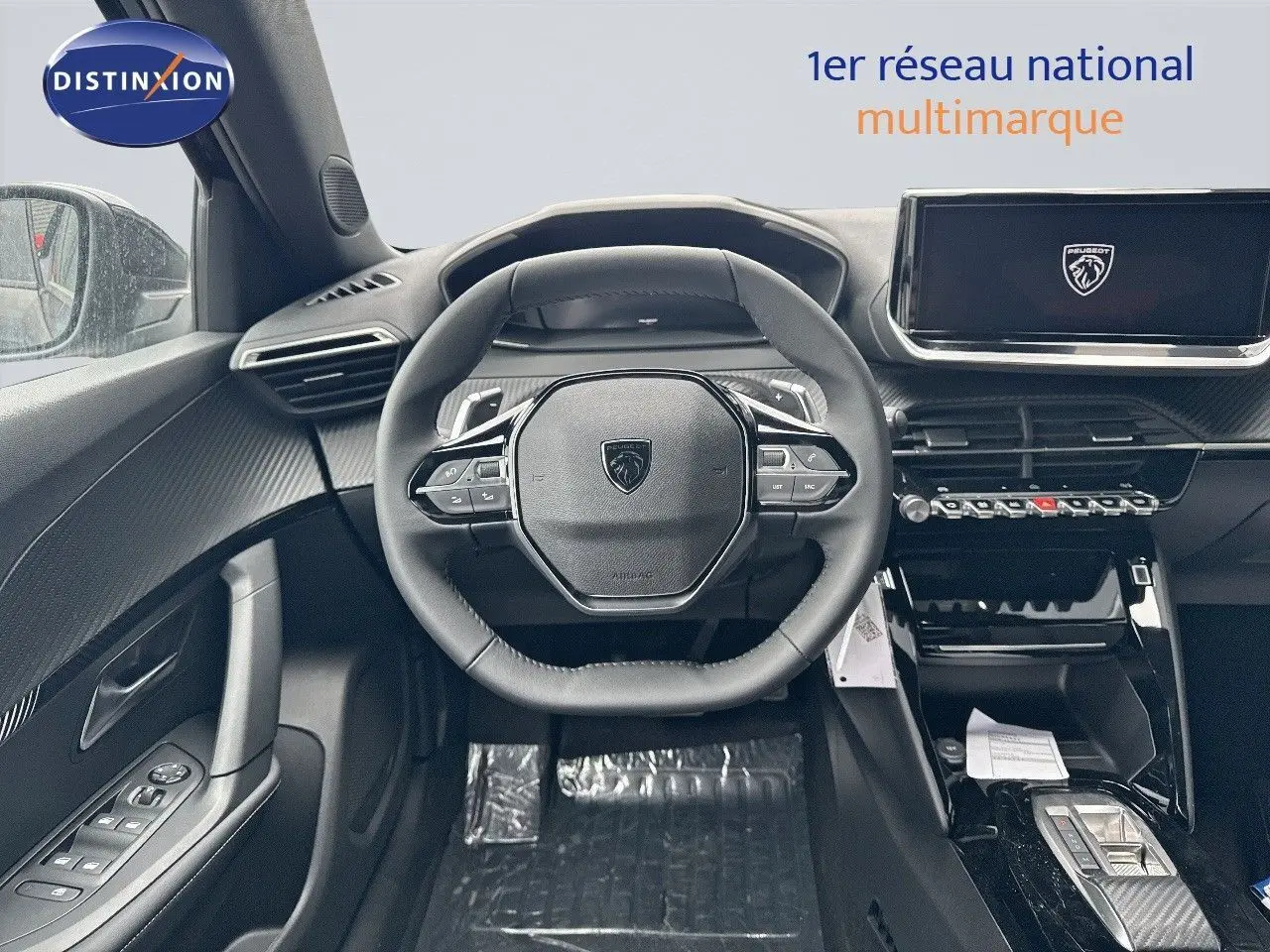 Intérieur noir du Peugeot 2008 Hybrid 136ch Allure 2025, vue frontale du volant et tableau de bord digital.