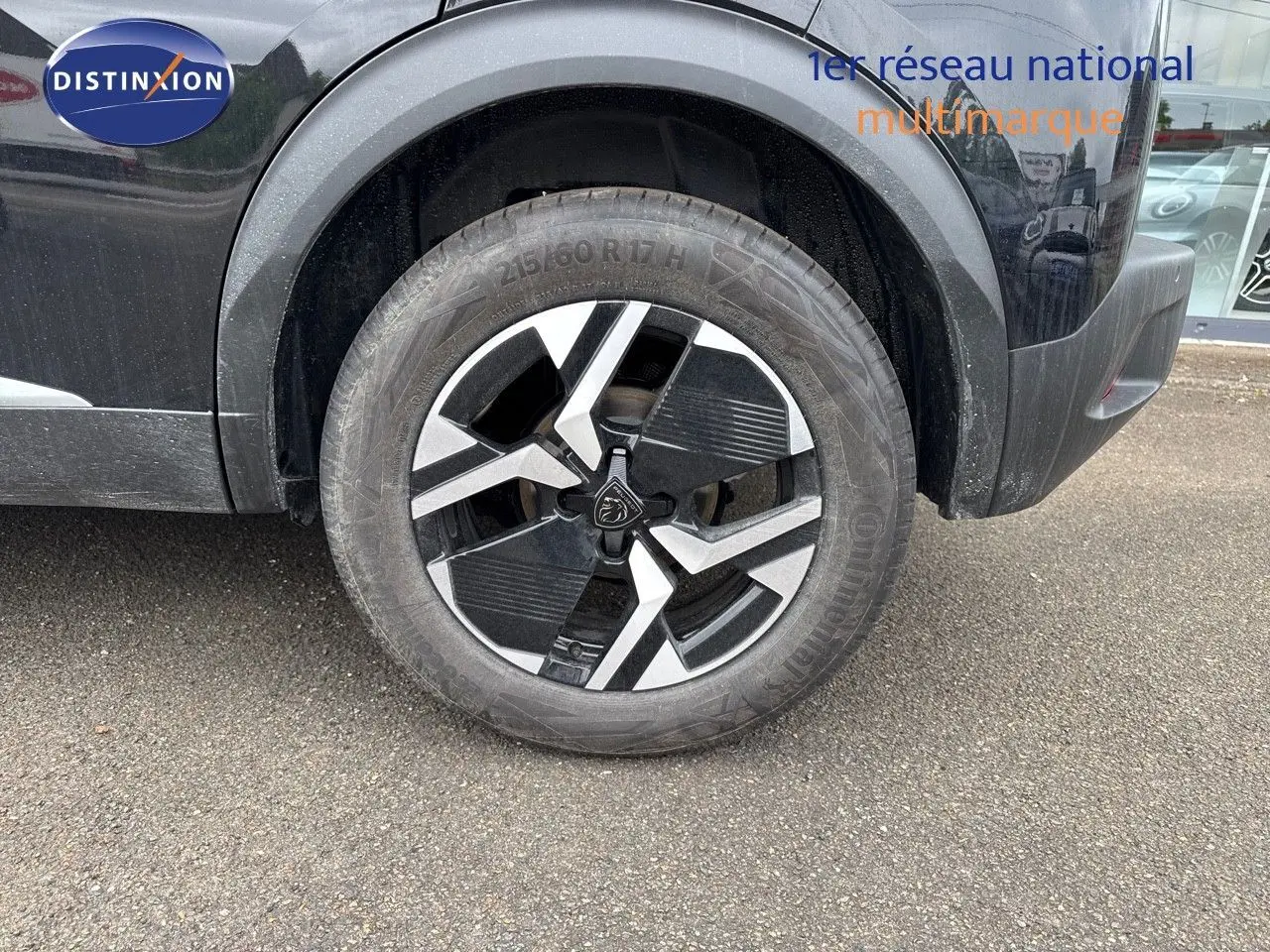 Gros plan sur la roue avant gauche du Peugeot 2008 noir métal avec jante alliage bicolore distinctive.