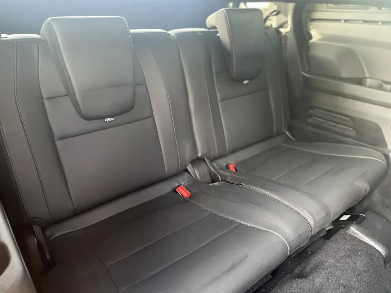 Vue rapprochée sur la banquette arrière en cuir noir du Renault Espace 2024, version hybride 7 places.