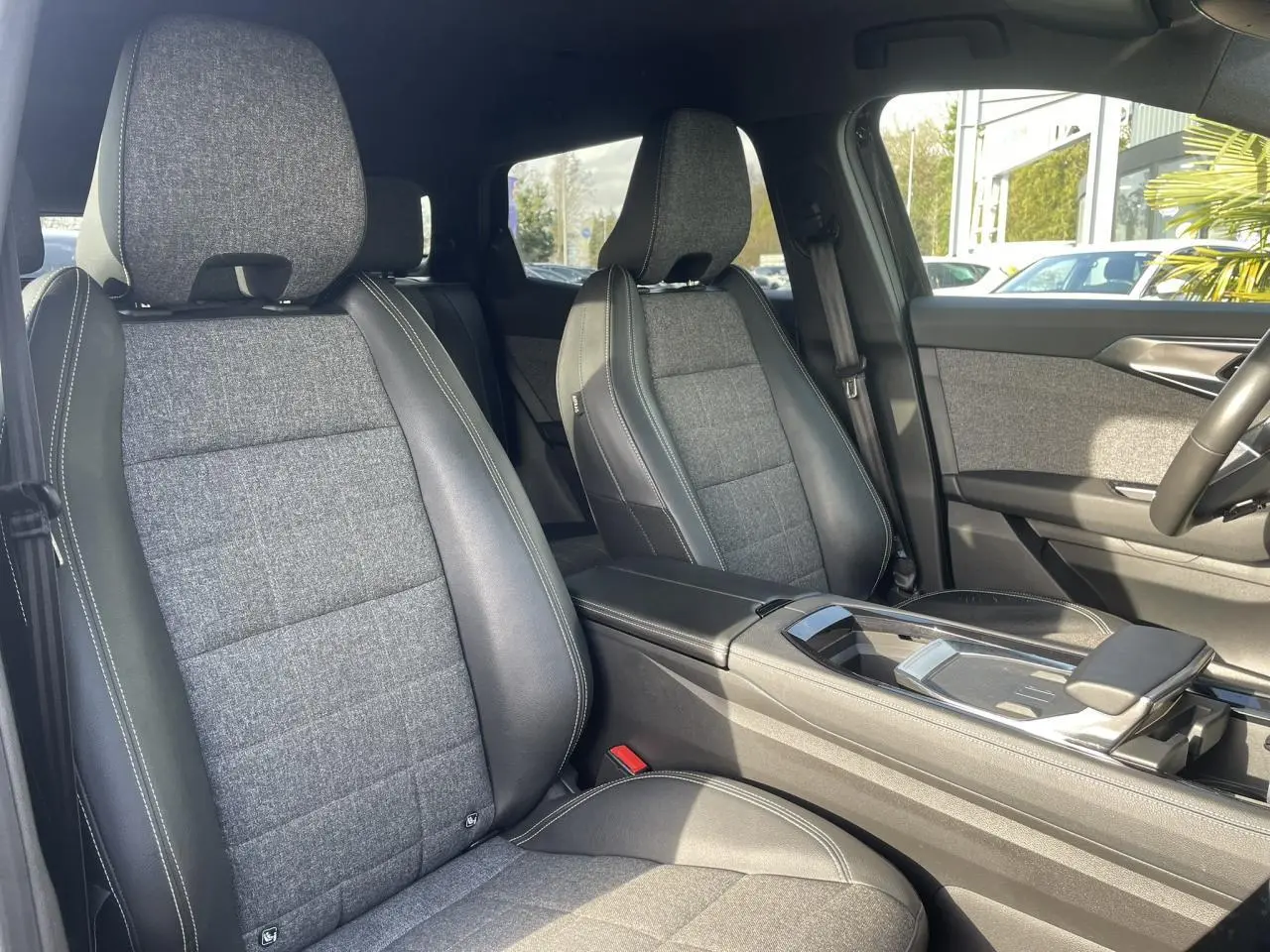 Vue intérieure côté avant droit montrant les sièges tissu gris et cuir noir du Renault Espace 2024 E-Tech Hybrid.