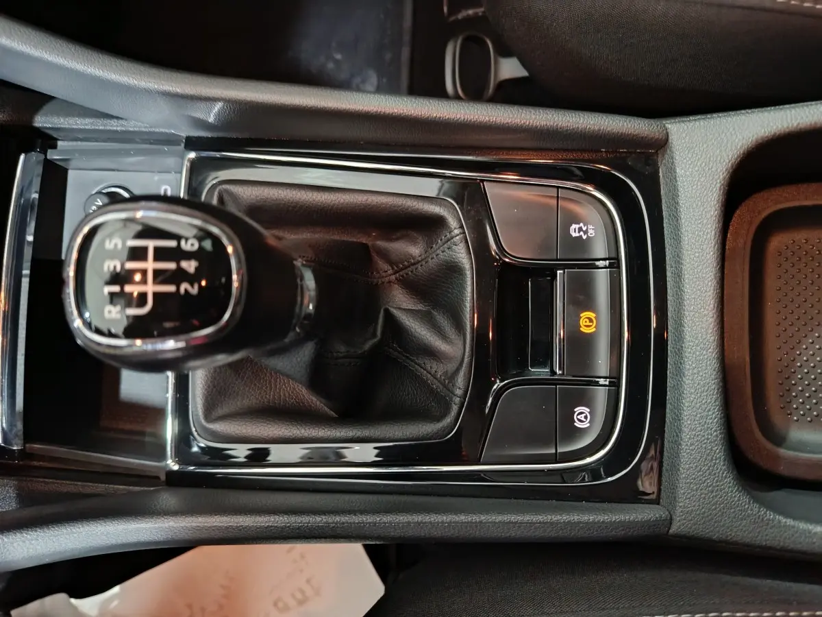 Vue rapprochée du levier de vitesse manuel noir et des commandes électroniques de la console centrale du Skoda Karoq 2024.