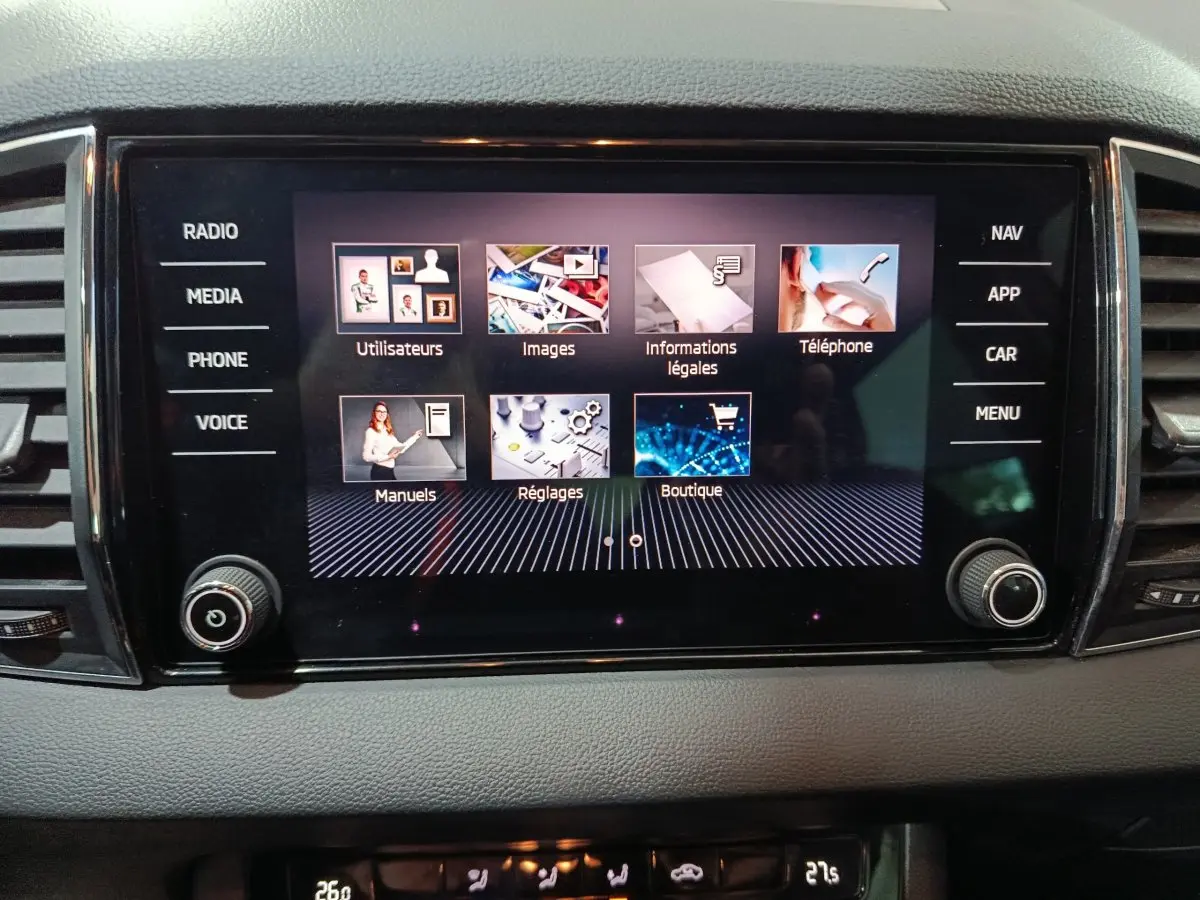Écran tactile central noir affichant le menu multimédia du Skoda Karoq blanc, vue intérieure frontale.
