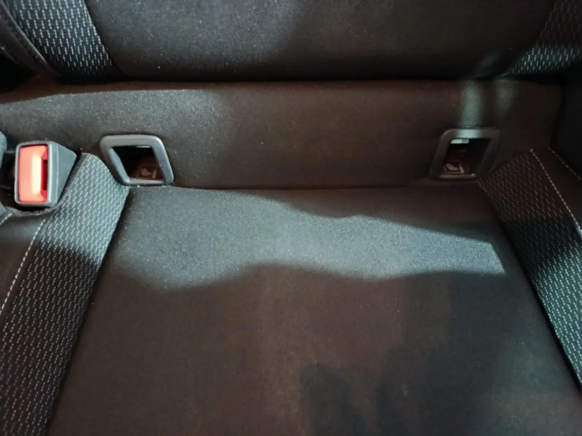 Gros plan sur l'assise arrière noire avec ceintures et fixations Isofix du Skoda Karoq 2024 blanc.