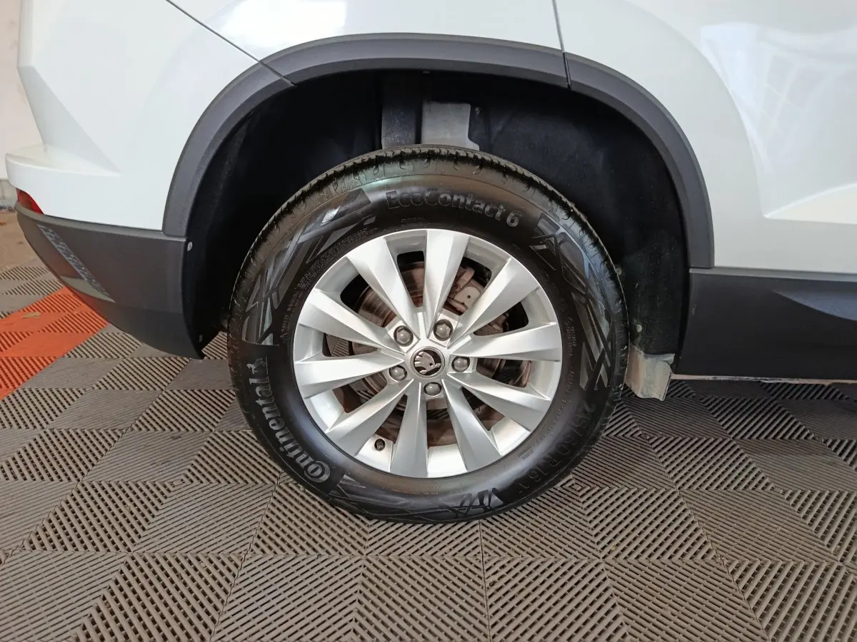 Gros plan sur la roue arrière droite d’un Skoda Karoq blanc 2024, avec jante alliage et pneu Continental.