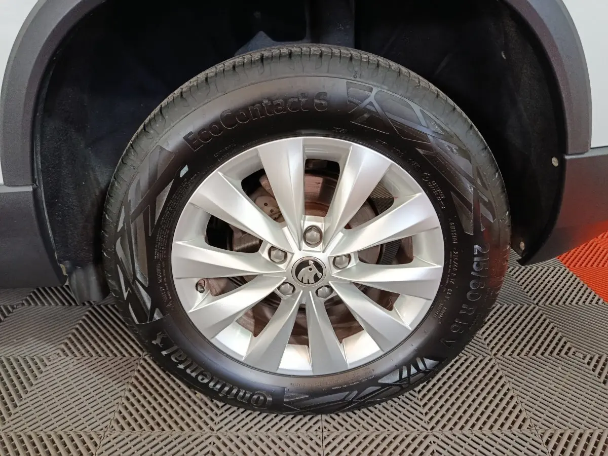 Gros plan sur la roue avant droite blanche d’un Skoda Karoq 2024 avec jante alliage et pneu Continental.